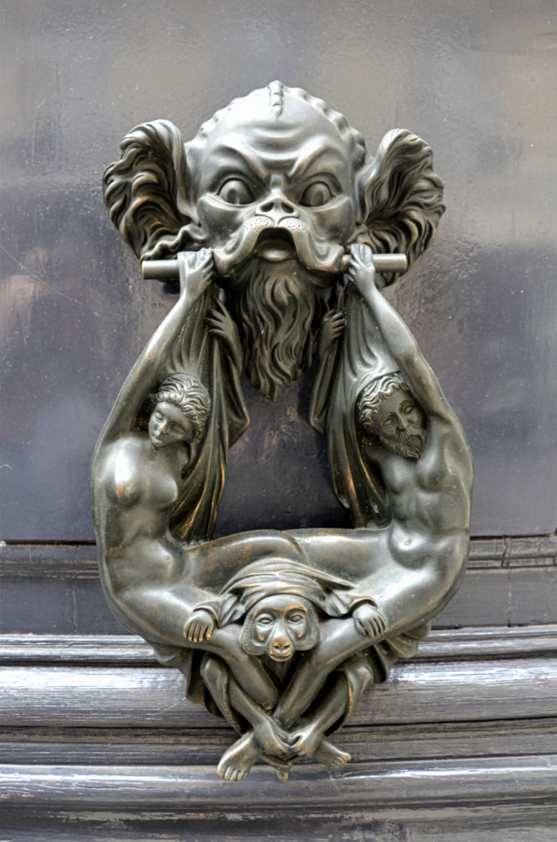 Sculptural bronze door knocker with figures and masks